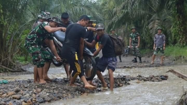 Anggota Satgas TMMD Kodim 0212/Tapsel Bantu Warga Menyeberangi Sungai